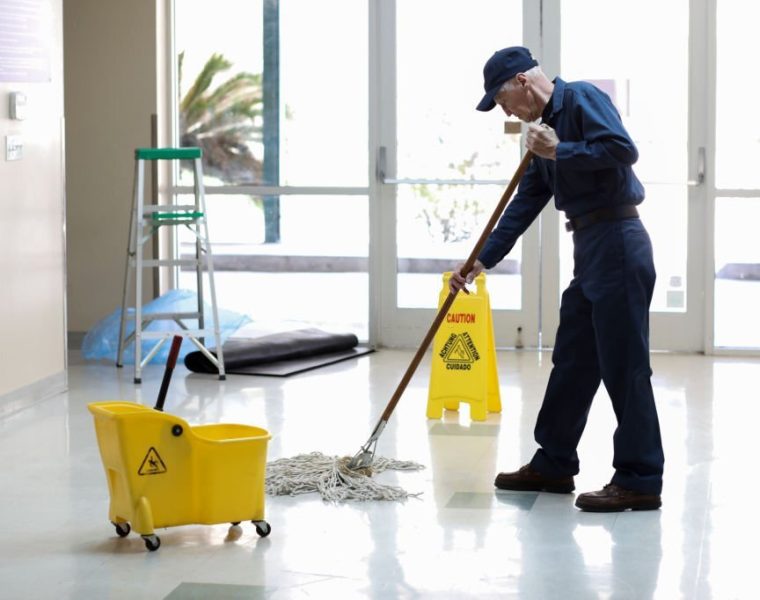 Senior adult Janitor keeps the floors cleaned and sanitized due to the virus.