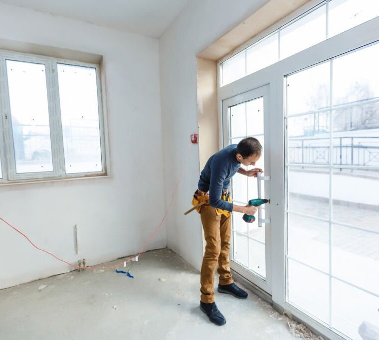 Worker in glazier's workshop, warehouse or storage handling glass