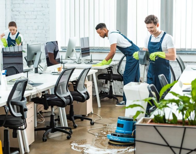 multicultural team of cleaners working in modern open space office